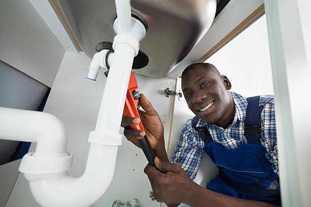 Young African Handyman Repairing Sink Pipe With Worktool